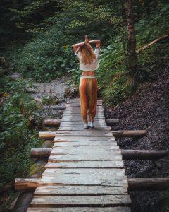 woman walking on a bridge for her hike through the mountains 